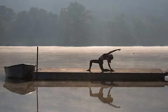 Yoga im Morgennebel auf einem Steg